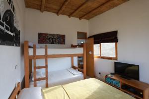 1 dormitorio con 2 literas y TV de pantalla plana en Lobitos Eco Lodge en Lobitos