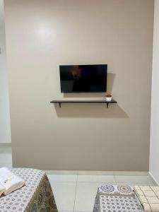 a flat screen tv on a white wall at Sol do Caribe Suítes in Maragogi