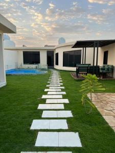 um jardim com um caminho de pedra em frente a uma casa em HAFAL Resort شاليهات هافال em Riade