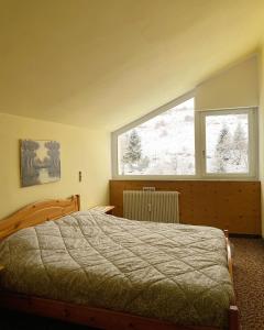 Merlin Malga San Giorgio 6 في بوسكو تيسانيوفا: غرفة نوم بها سرير ونافذة كبيرة