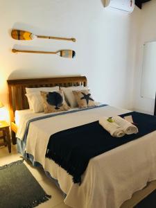 a bedroom with a large bed with towels on it at Canto do Una- hospedagem in Barra do Una