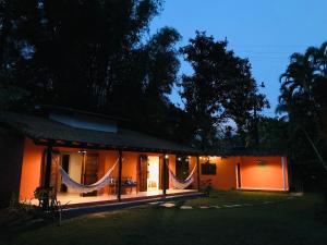 a house with curtains on the front of it at night at Hospedagem Canto do Una in Barra do Una