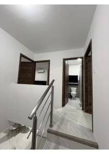 - un escalier avec un miroir et des toilettes dans la chambre dans l'établissement Casa Familiar a Pasos del Mar Playa y Felicidad, à Manta