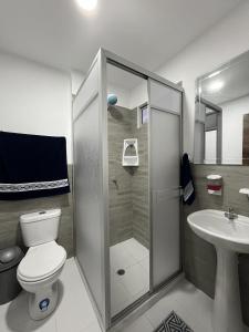uma casa de banho com um chuveiro, um WC e um lavatório. em Casa Familiar a Pasos del Mar Playa y Felicidad em Manta