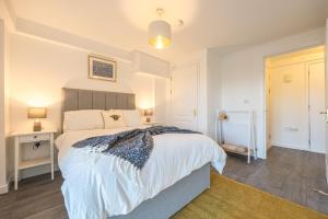 a bedroom with a large white bed and a lamp at Victoria Brand new, cosy 1 bed apartment in London
