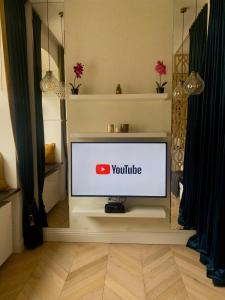 uma televisão numa sala com um sinal do YouTube em Cozy Apartment on Piotrkowska Street em Lódź