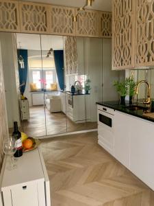 a kitchen with white cabinets and a counter top at Cozy Apartment on Piotrkowska Street in Łódź