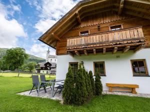 a house with a wooden roof and a table and chairs at Wolfgangchalet C in Mauterndorf