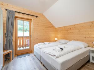 ein großes weißes Bett in einem Zimmer mit Fenster in der Unterkunft Wolfgangchalet C in Mauterndorf