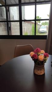 un jarrón de flores en una mesa frente a una ventana en Apartamento RE real de San Carlos en Colonia del Sacramento