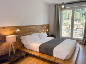 a bedroom with a large bed and a large window at Iconic - Terraza Con Increibles Vistas Al Valle de ARINSAL - 6PAX - SENDERISMO & ESQUÍ - Free Parking in Arinsal