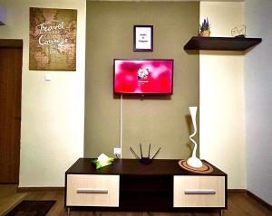 uma sala de estar com uma mesa e uma televisão na parede em ROOR Top Nest 3 em Gheorgheni