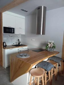 Domek na Górce في زاكوباني: مطبخ مع كونتر خشبي مع كراسي