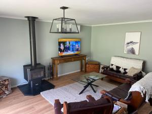 a living room with a wood stove and a tv at 3 Bedroom Holiday house in Halls Gap