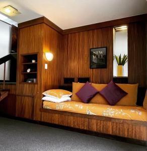 a bed in a room with a wooden wall at Spacious Hideaway Retreat, Brookfield, Brisbane in Brisbane
