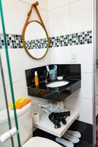 a bathroom with a sink and a mirror at Otimo studio c WiFi no centro de Pedro Leopoldo MG in Pedro Leopoldo