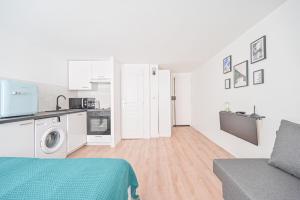 a white apartment with a kitchen and a living room at Studio Cosy 2/4P - République in Paris