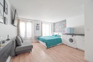 a white room with a bed and a washing machine at Studio Cosy 2/4P - République in Paris