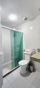uma casa de banho com um WC e uma cabina de duche em vidro. em Zenith em Arraial do Cabo