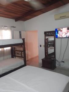 a bedroom with a bunk bed and a flat screen tv at VIVIENDA TURISTICA GAIRA in Rodadero