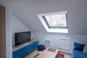 ein Wohnzimmer mit einem TV und einem blauen Schrank in der Unterkunft Le Champs-Elysees - Cité universitaire Paris 14 in Gentilly