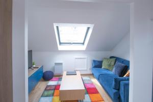 ein Wohnzimmer mit einem blauen Sofa und einem Tisch in der Unterkunft Le Champs-Elysees - Cité universitaire Paris 14 in Gentilly