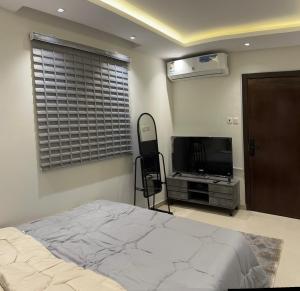 1 dormitorio con 1 cama y TV de pantalla plana en استديو مدخل خاص ودخول ذاتي, en Riad