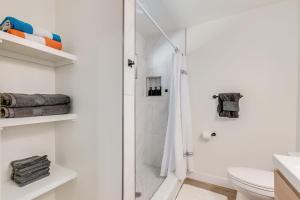 a white bathroom with a shower and a toilet at Bright New Beach House with In- Law Suite -- 2 blocks to beach! in St. Augustine