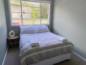 a bed in a room with a large window at 3 Bedroom Holiday house in Halls Gap