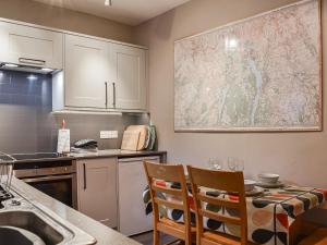 a kitchen with a sink and a table with chairs at Lingmoor View in Ambleside