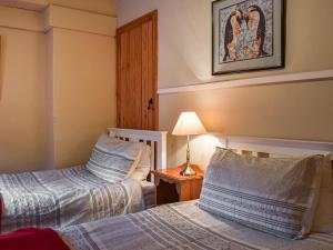 a bedroom with two beds and a lamp on a table at Lingmoor View in Ambleside