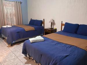1 dormitorio con 2 camas y una lámpara en una mesa en Hotel Xucaneb, en Cobán