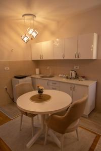 a kitchen with a table and chairs in a kitchen at Lotos Apartments in Kruševac