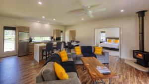 a living room with a couch and a kitchen and a bed at Quaffers on Storm King in Stanthorpe