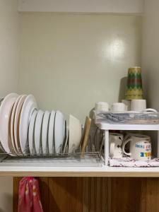 a shelf with plates and other dishes on it at Cozynest Condotel Baguio in Baguio
