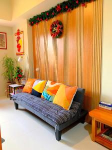 un sofá con almohadas de colores en la sala de estar. en Cozynest Condotel Baguio, en Baguio