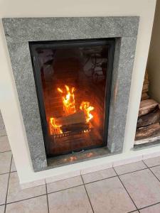 a fireplace with a fire inside of it at Villa ski proche de Genève et du Jura in Saint-Genis-Pouilly