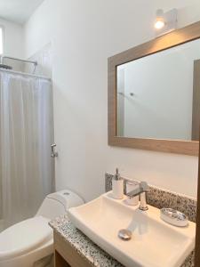 a bathroom with a sink and a toilet and a mirror at Suite 5, Las Castañas in Manglaralto