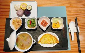 a tray of food with bowls of soup and vegetables at AQUA Tree Resort in Fengbin