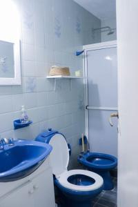 a bathroom with a blue toilet and a sink at LA CASA DE LA NONA in Guaymallen
