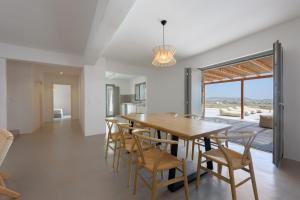 a kitchen and dining room with a wooden table and chairs at Aegean Gem Villa with private pool in Paros in Mármara