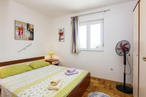 Schlafzimmer mit einem Bett, einem Fenster und einem Ventilator in der Unterkunft Apartments by the sea Pirovac, Sibenik - 15659 in Pirovac