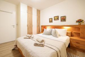 a bedroom with a bed with two towels on it at Luxury villa with a swimming pool Poljica, Zadar - 22070 in Vrsi +22 photos