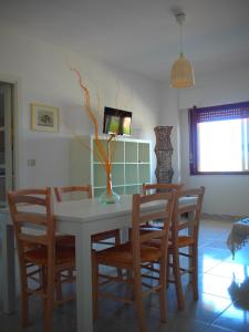 ein Esszimmer mit einem weißen Tisch und Stühlen in der Unterkunft Pace 27 in Alghero