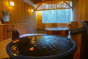 eine große Badewanne in einem Zimmer mit Orangen in der Unterkunft 北軽井沢　Golden Forest Hotel in Naganohara