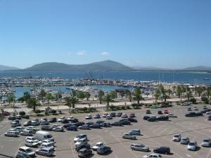 ein Parkplatz mit geparkten Autos und ein Yachthafen in der Unterkunft Pace 27 in Alghero