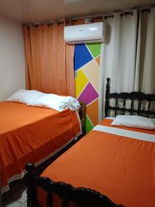 dos camas sentadas una al lado de la otra en una habitación en Donde missluz inn en San Andrés