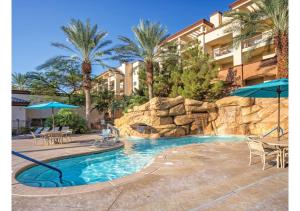 einen Pool in einem Resort mit Stühlen und Sonnenschirmen in der Unterkunft Deluxe 3-BR Condo - Lazy River Summer Fun - Special Offer Now! in Las Vegas