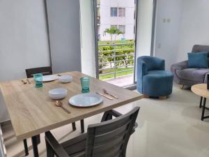 uma mesa de madeira e cadeiras numa sala de estar em ¡Hermoso y cómodo apartamento! em Ibagué