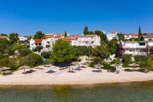 an aerial view of a beach with umbrellas at Apartments by the sea Pirovac, Sibenik - 6447 in Pirovac